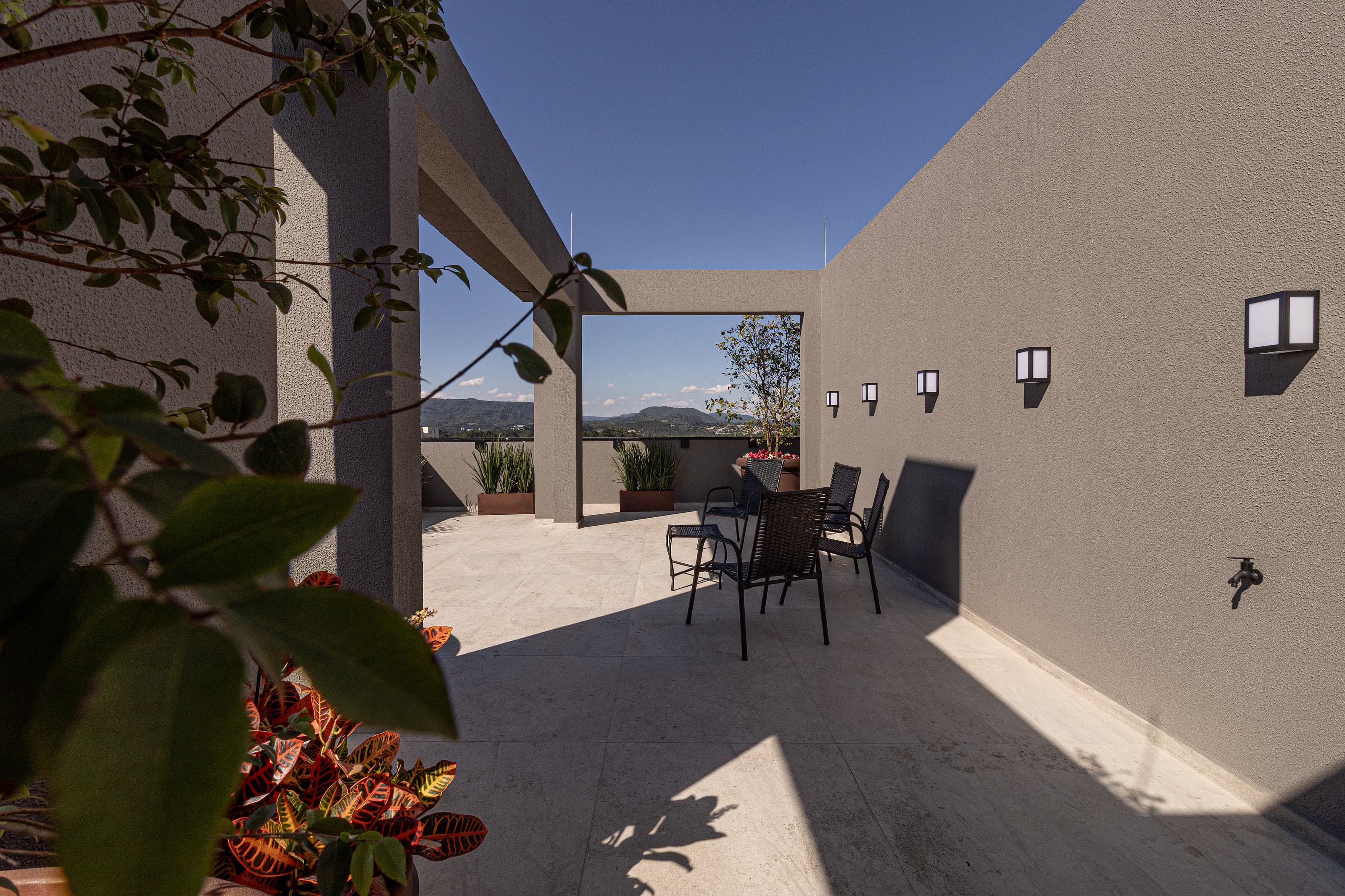 Cobertura jardim com cadeiras e vista para os morros