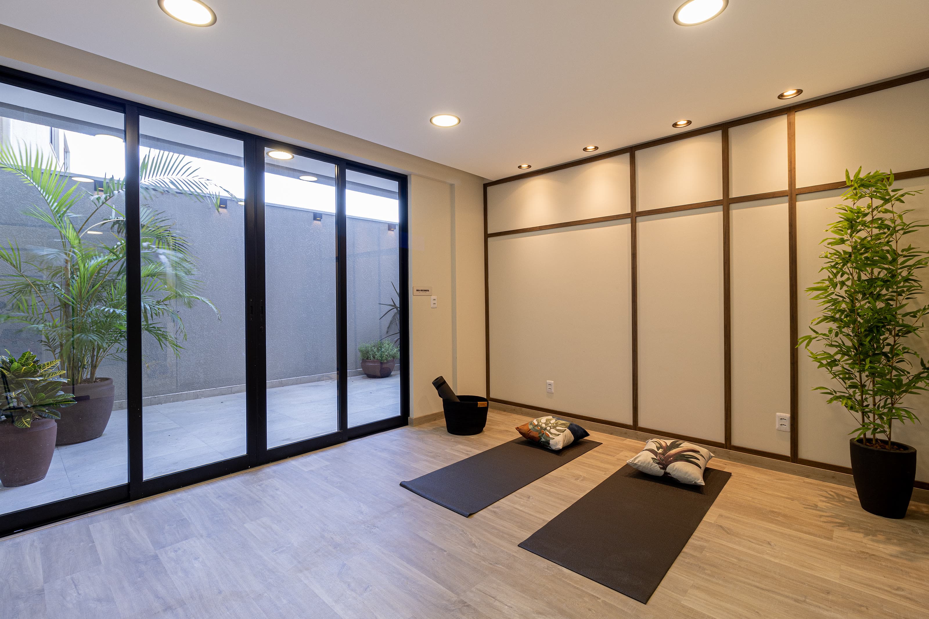 Espaço zen com tapetes de yoga e jardim interno