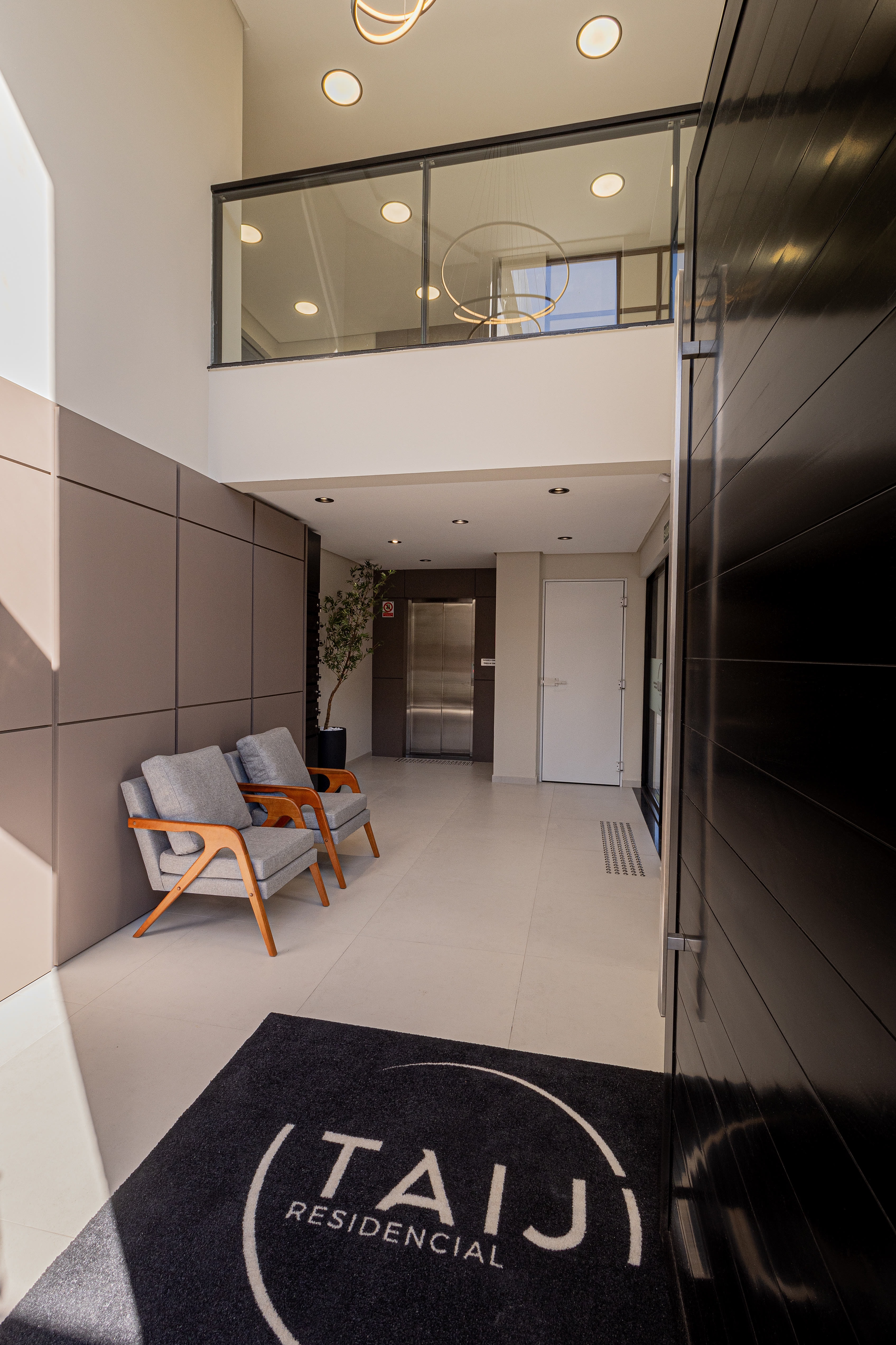 Hall de entrada com poltronas e pé-direito duplo